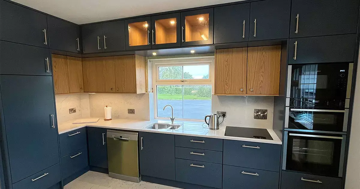 Bespoke kitchens in Kilkenny featuring full-height navy cabinetry, oak interiors and custom quartz worktops